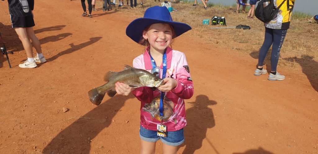 Girl Smiling And Holding A Fish